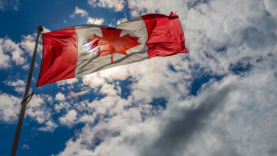 Canadian Flag with blue sky and clouds