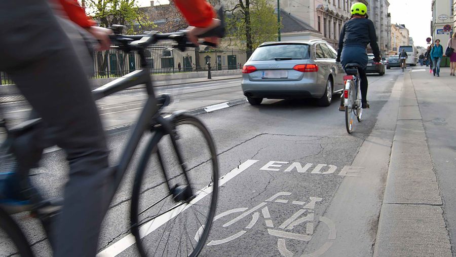 Bicycles on bike path near car