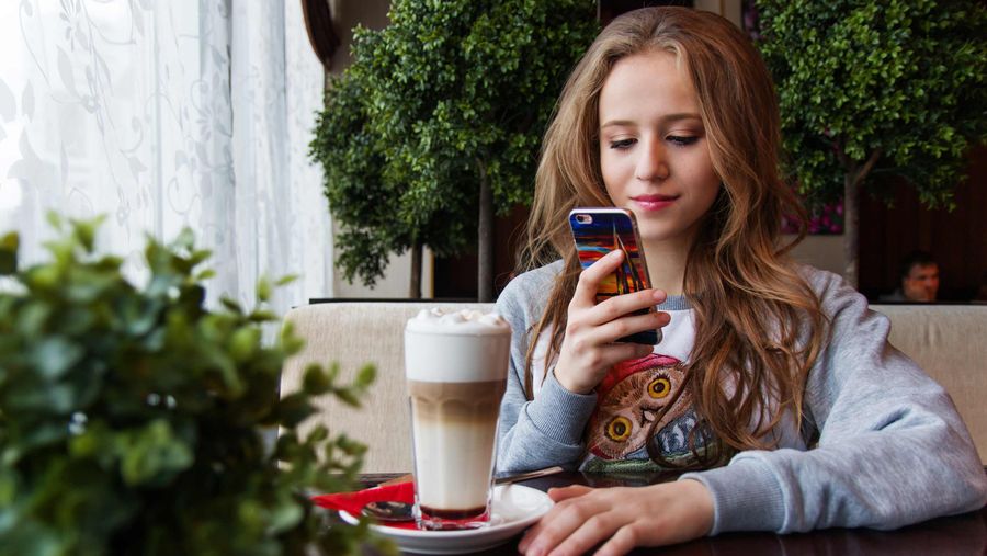 woman using phone in restaurant