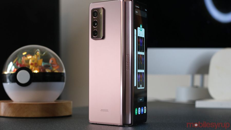 samsung's galaxy z fold standing with hinge front-facing beside a pokeball terrarium