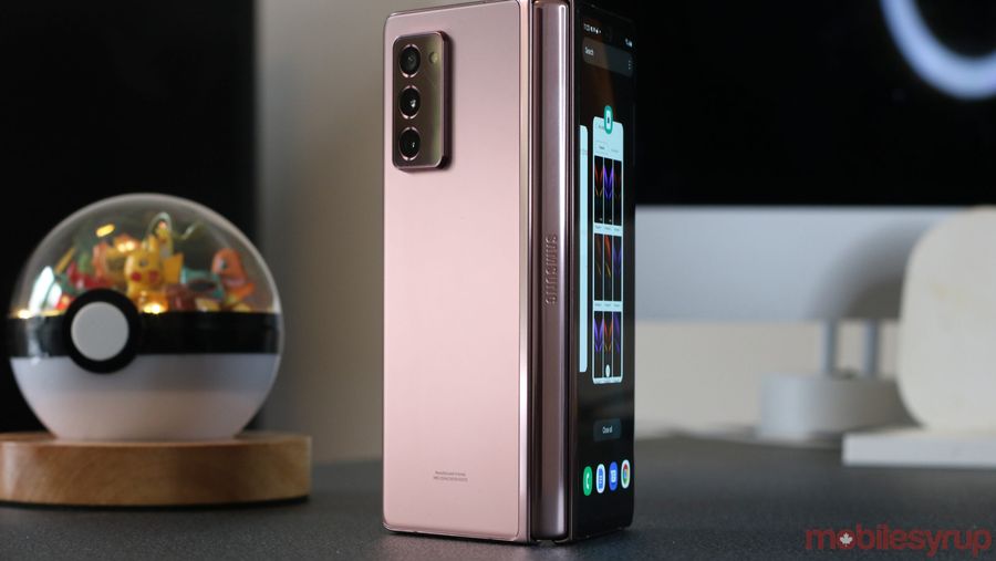 samsung's galaxy z fold standing with hinge front-facing beside a pokeball terrarium