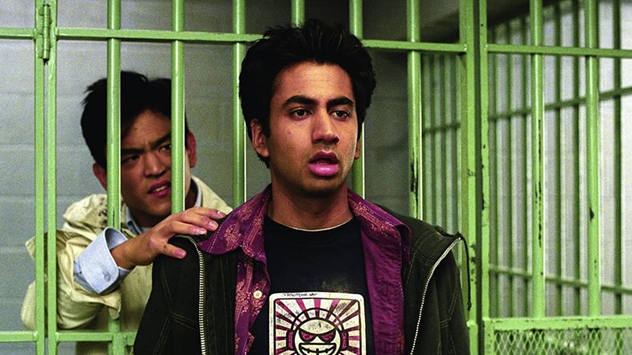 kumar in front of a jail cell and harold is in the cell