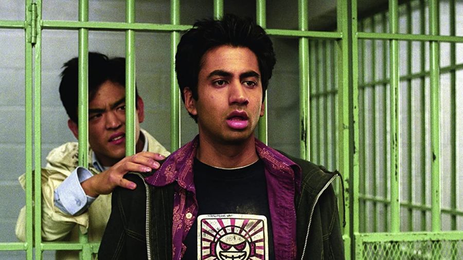 kumar in front of a jail cell and harold is in the cell