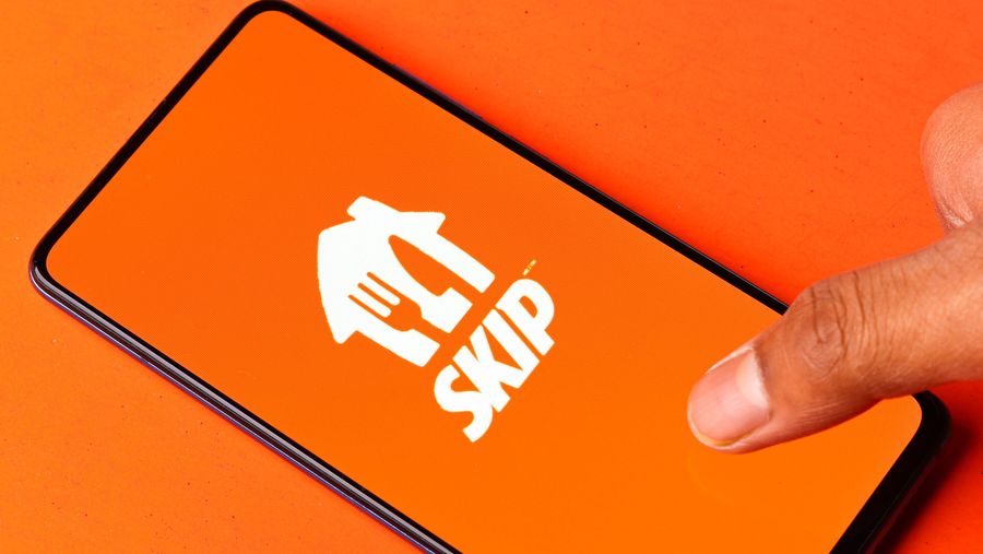 Skip logo on a smartphone against an orange background