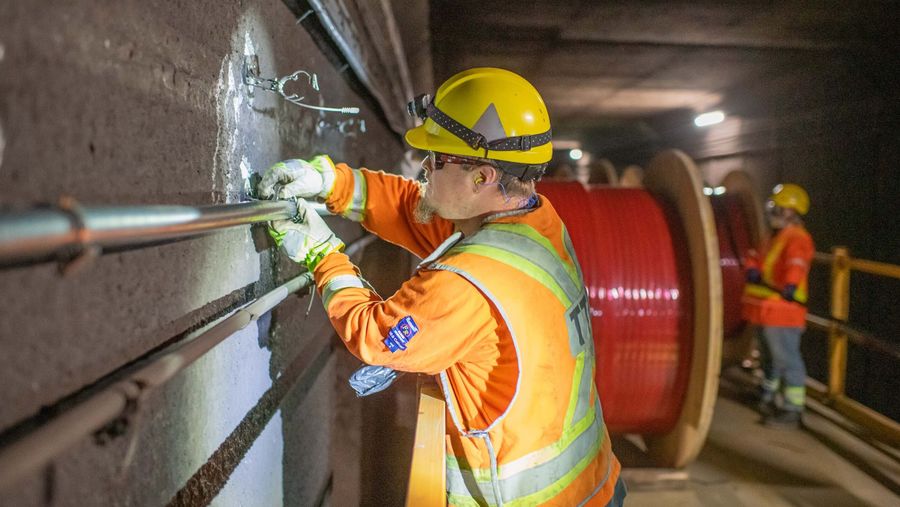 TTC electrician installing Rogers cable in a subway tunnel.