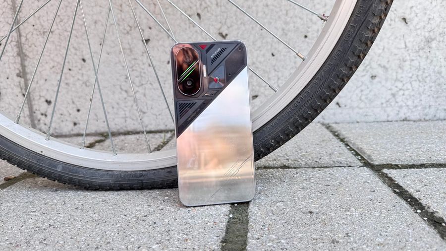 A silver and black POCO F7 leads against a bicycle tire.