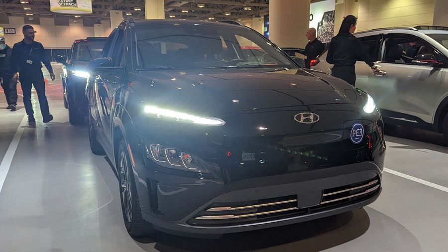 Hyundai Kona EV with bright headlights.